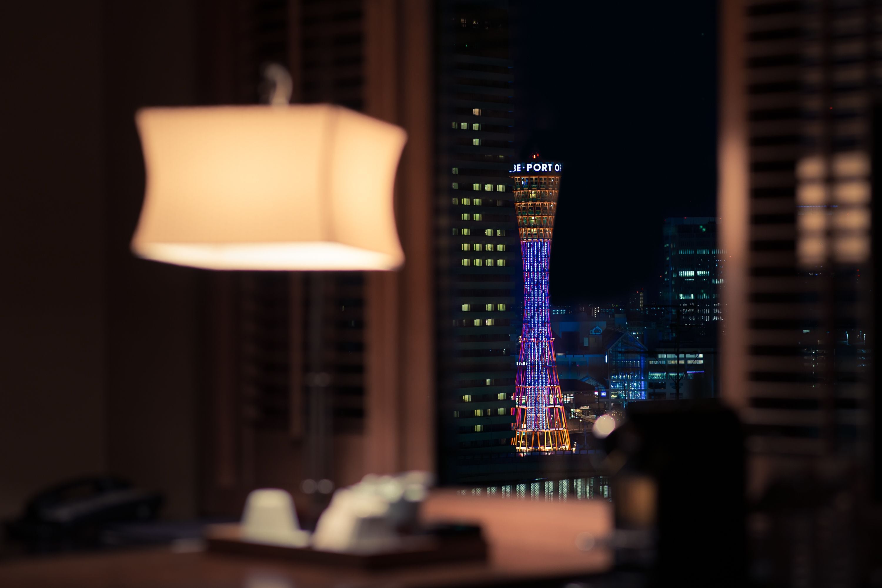 A room with a view of a brightly lit tower at night.