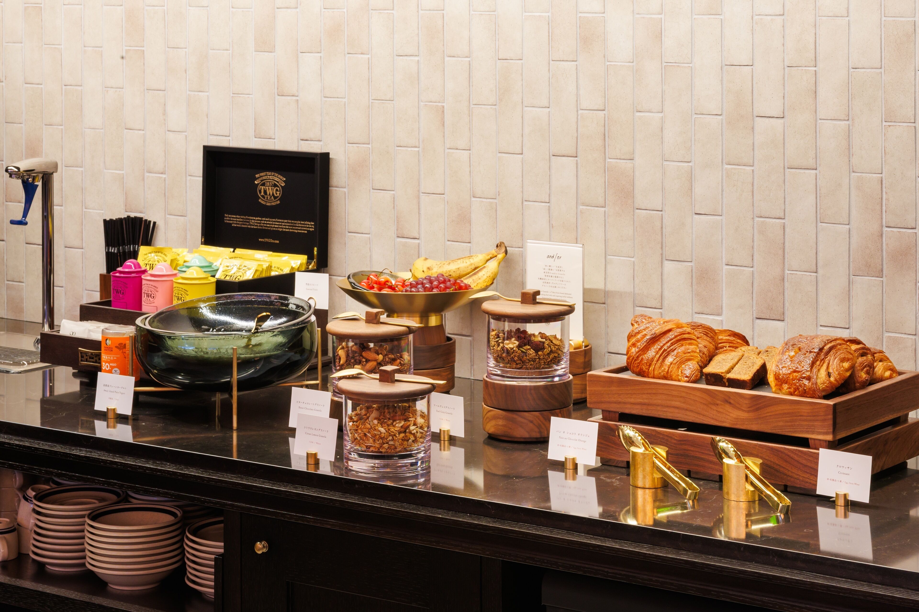 Mostrador de buffet con diversos alimentos, como frutas, pasteles y salsas.