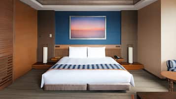 A hotel room with a large bed, a nightstand with a lamp, a telephone, and a chair.