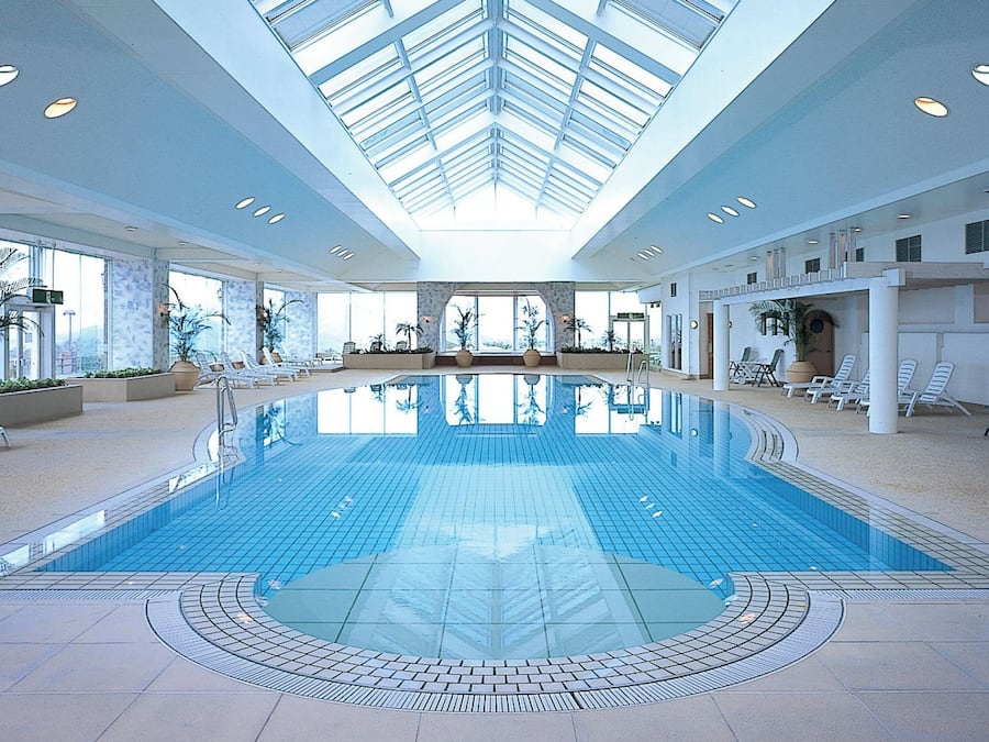 Una piscina techada, sillones reclinables de piscina