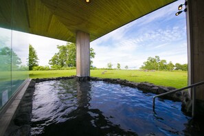 A hot tub area with a view of a grassy landscape and trees. - The Windsor Hotel Toya, Vignette Collection by IHG (Toyako)