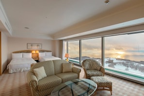 A hotel room with a large bed, two bedside tables, a sofa, a chair, and a glass coffee table. - The Windsor Hotel Toya, Vignette Collection by IHG (Toyako)