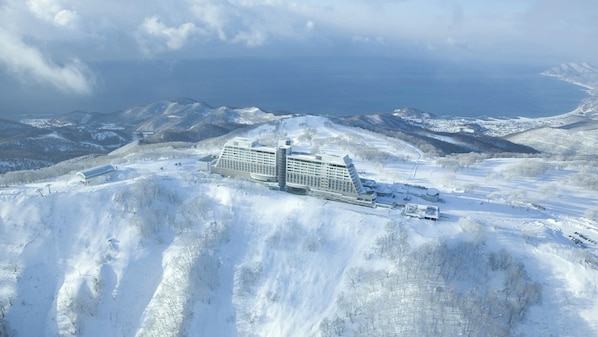 A large cruise ship docked at a port with snow-covered hills in the background. - The Windsor Hotel Toya, Vignette Collection by IHG (Toyako)
