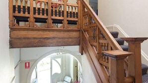 Eine Holztreppe mit Geländer, die zu einer oberen Etage führt.