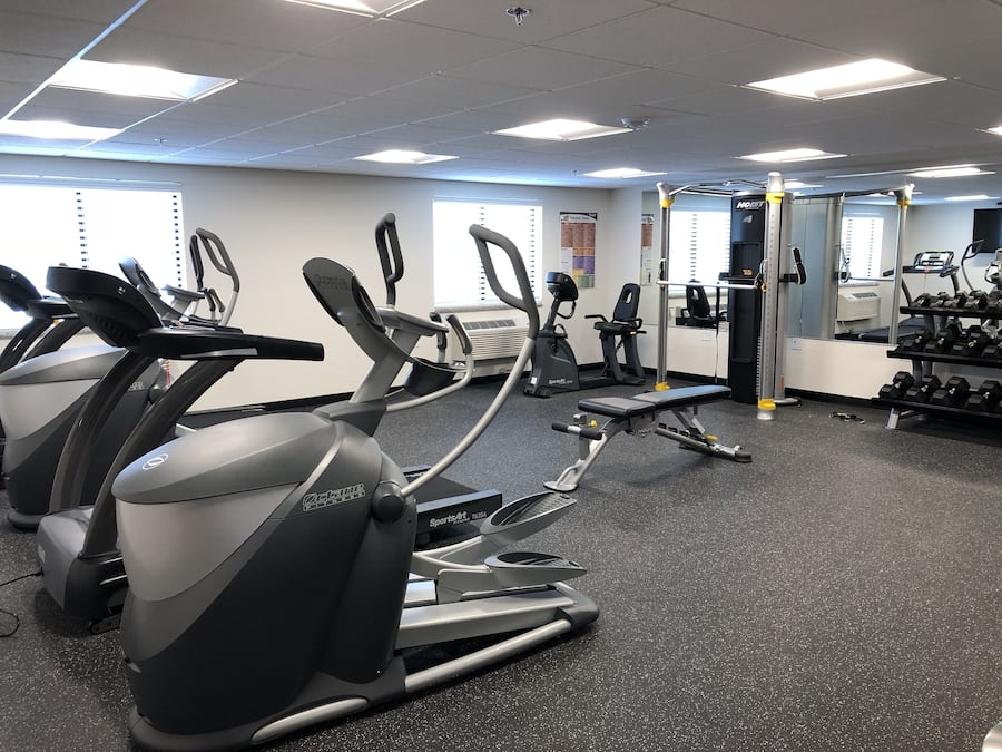 A gym with treadmills, elliptical machines, and weightlifting equipment.