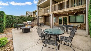 An outdoor patio area with a fire pit, seating, and a grill. - AmericInn by Wyndham Baudette (Baudette)