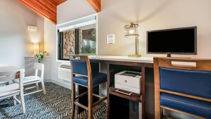 A business center with a desk, chairs, a printer, a monitor, and a sign indicating complimentary printing hours. - AmericInn by Wyndham Baudette (Baudette)