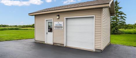A small, single-story building with a sign indicating it is an AmericInn Fish Cleaning Station.