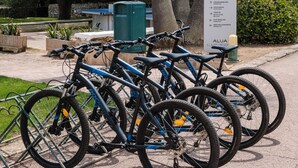 Bicycles parked near a sign listing amenities like tennis courts and a flat bowling area. - Aluasun Far Menorca (Sant Lluis)