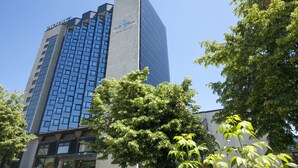 A modern hotel building with a glass facade and a prominent logo. -  Movenpick hotel Sarajevo (Sarajevo)