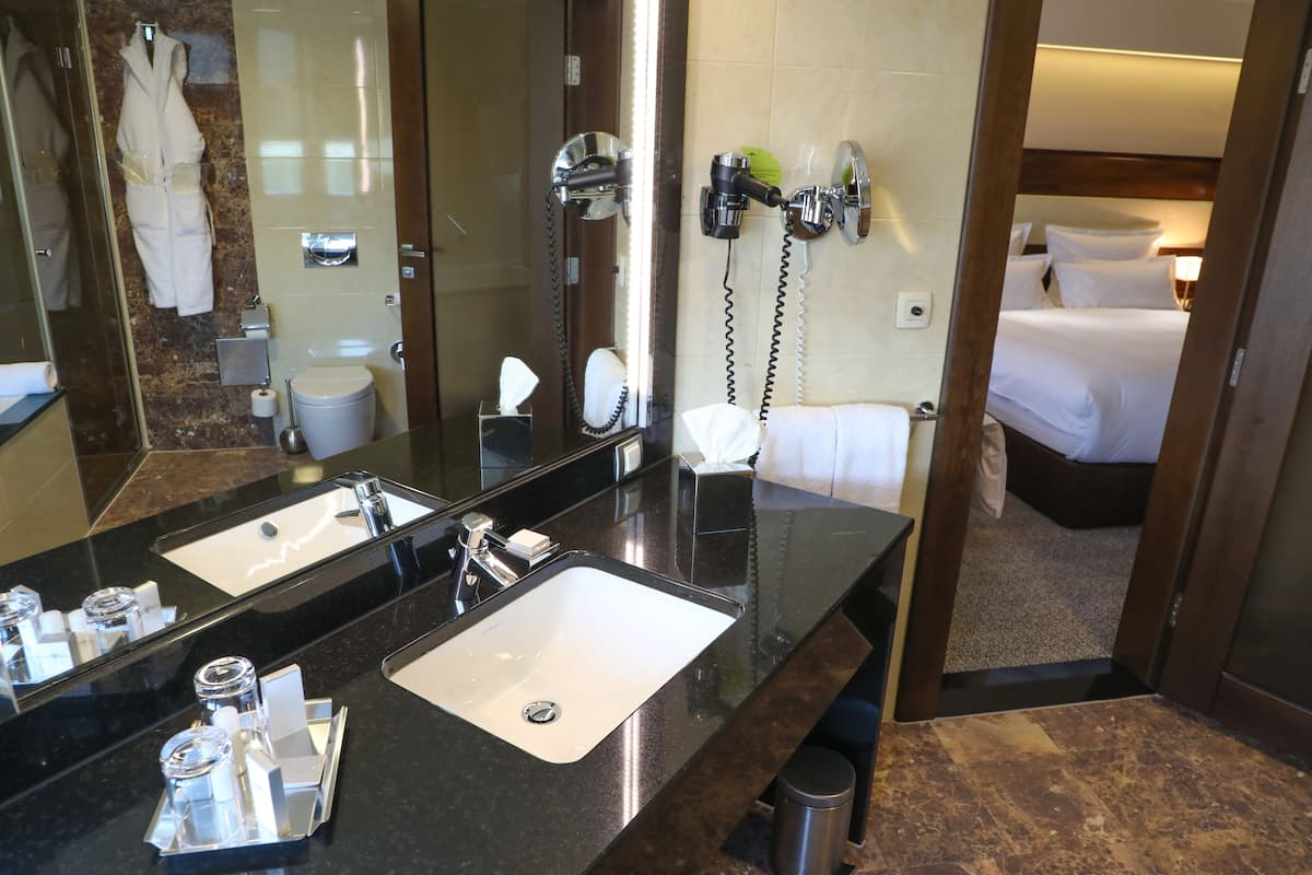 deluxe room, 1 king bed | bathroom | eco-friendly toiletries, hair dryer, slippers, towels