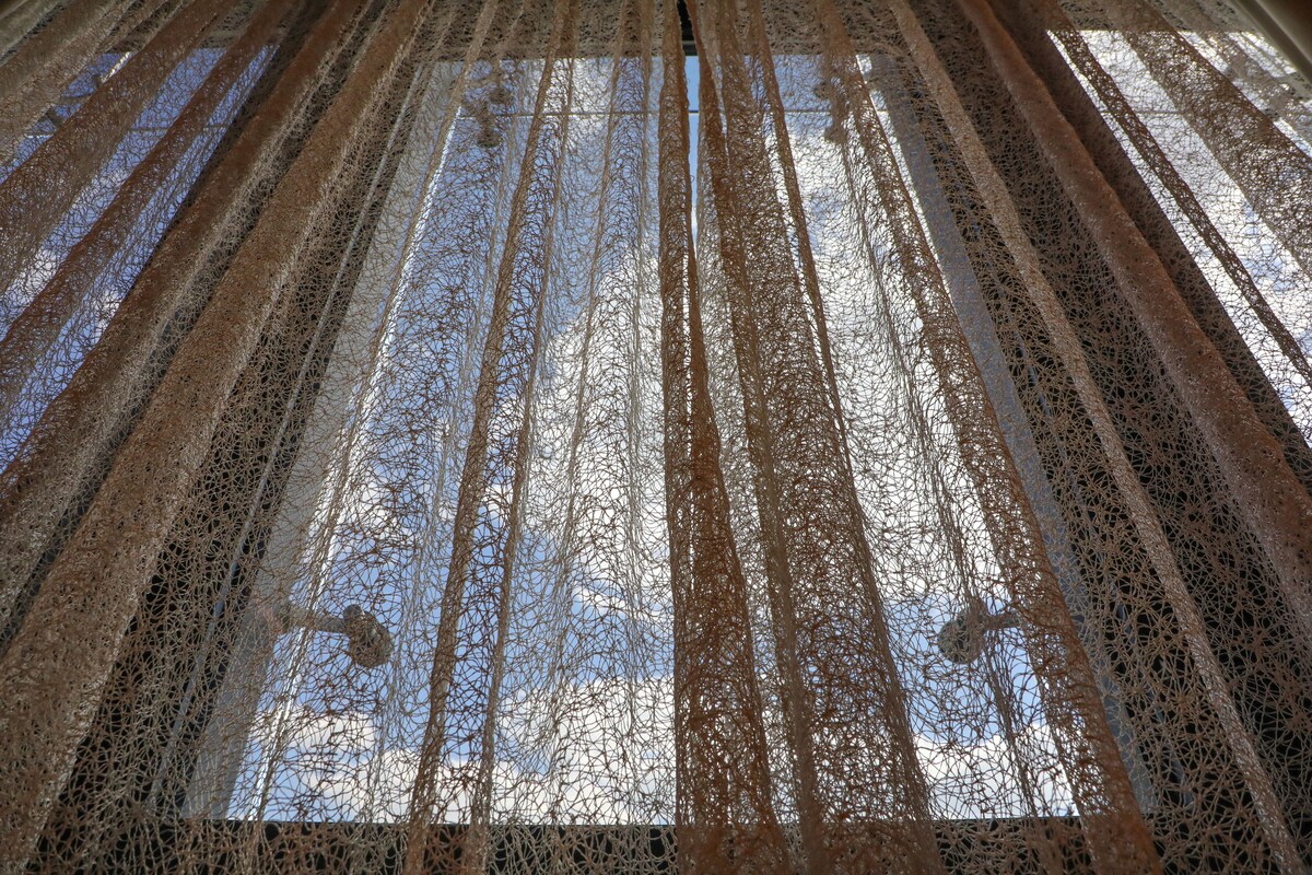 A view of a room with a patterned floor and a window with a view of the sky.