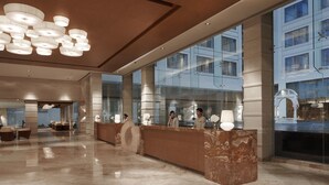 A spacious lobby with a marble reception desk, large windows, and a modern chandelier. - Jaipur Marriott Hotel (Jaipur)