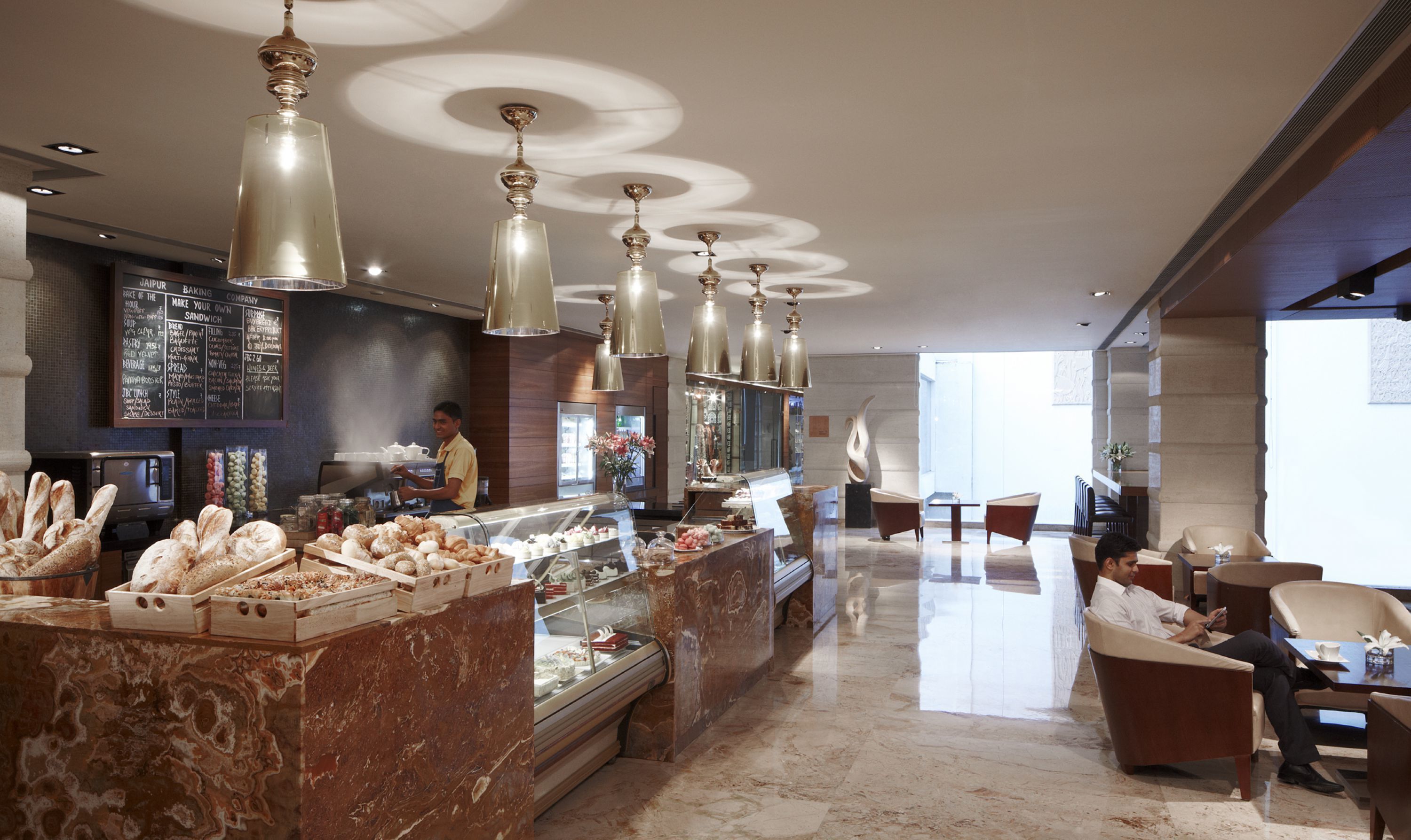 A bakery counter with pastries and a coffee bar with a menu.