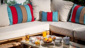 Ein gemütlicher Außenbereich mit einem Holztisch, gedeckt für ein Frühstück.