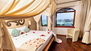 A room with a bed, a chair, a window with a view, and curtains. - Essque Zalu Zanzibar (Nungwi)
