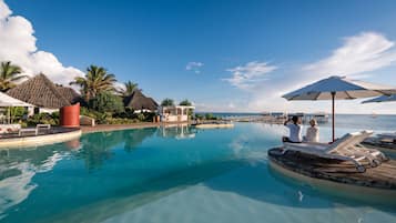 Een buitenzwembad, parasols voor strand/zwembad