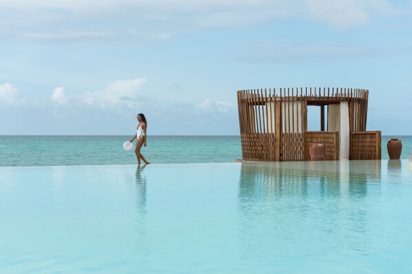 Una piscina al aire libre, sombrillas, tumbonas