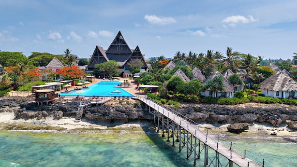 A resort with a clear blue pool, thatched-roof villas, and a wooden pier. - Essque Zalu Zanzibar (Nungwi)