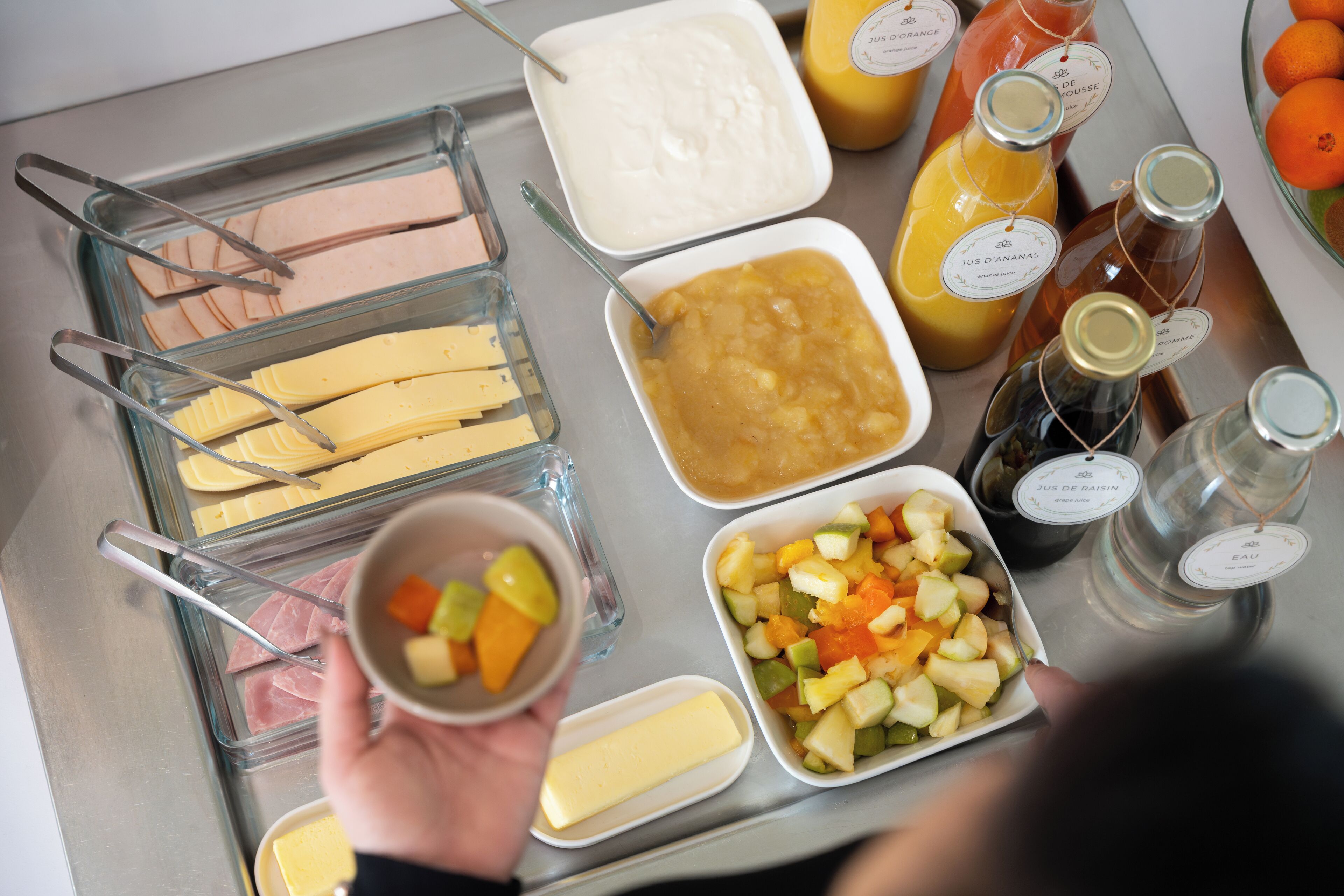 A buffet table with various food items and condiments.