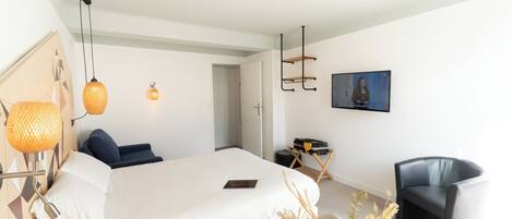 Un dormitorio moderno con una cama grande, un escritorio, una silla y una lámpara colgante.