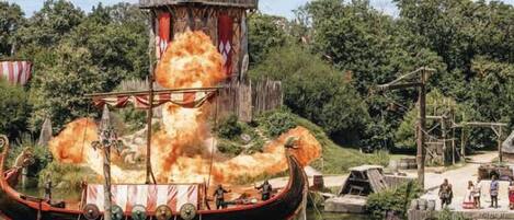 A Viking ship with a large explosion in the background.