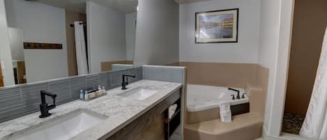 Un baño moderno con dos lavamanos, un espejo grande y una bañera.