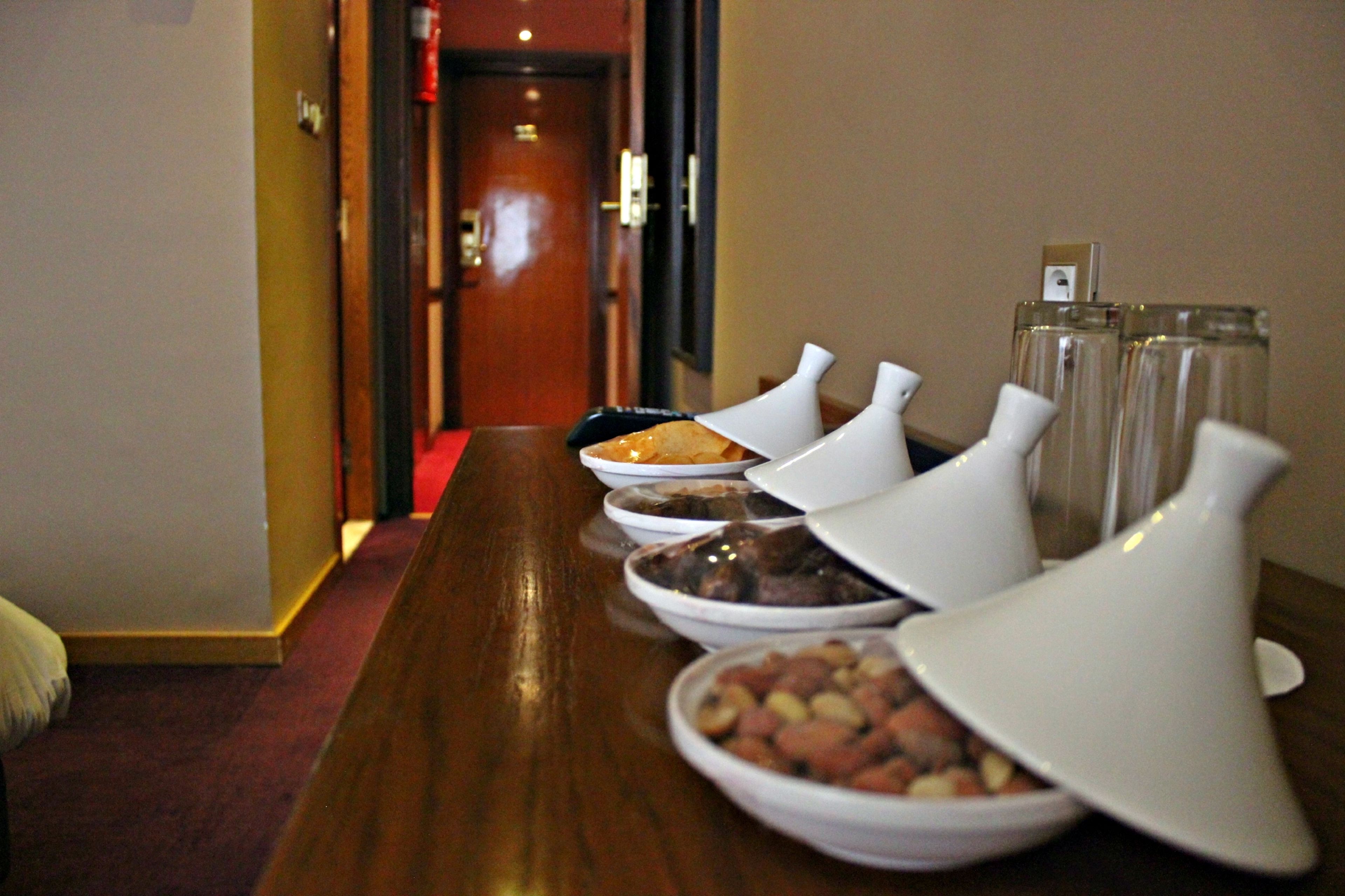 A long wooden table with various dishes and condiment containers.