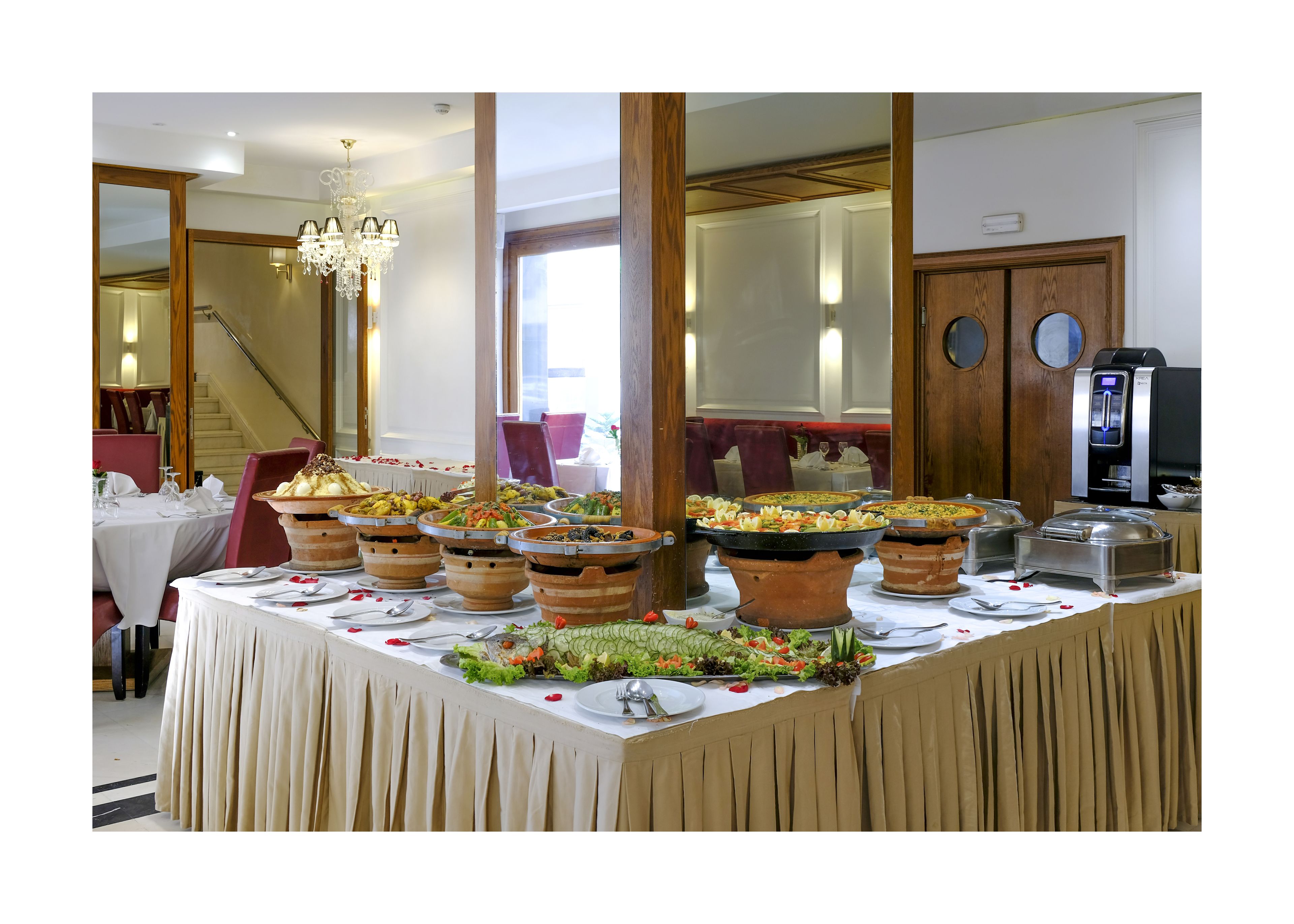 Un buffet avec plusieurs plats de service et une machine à café.