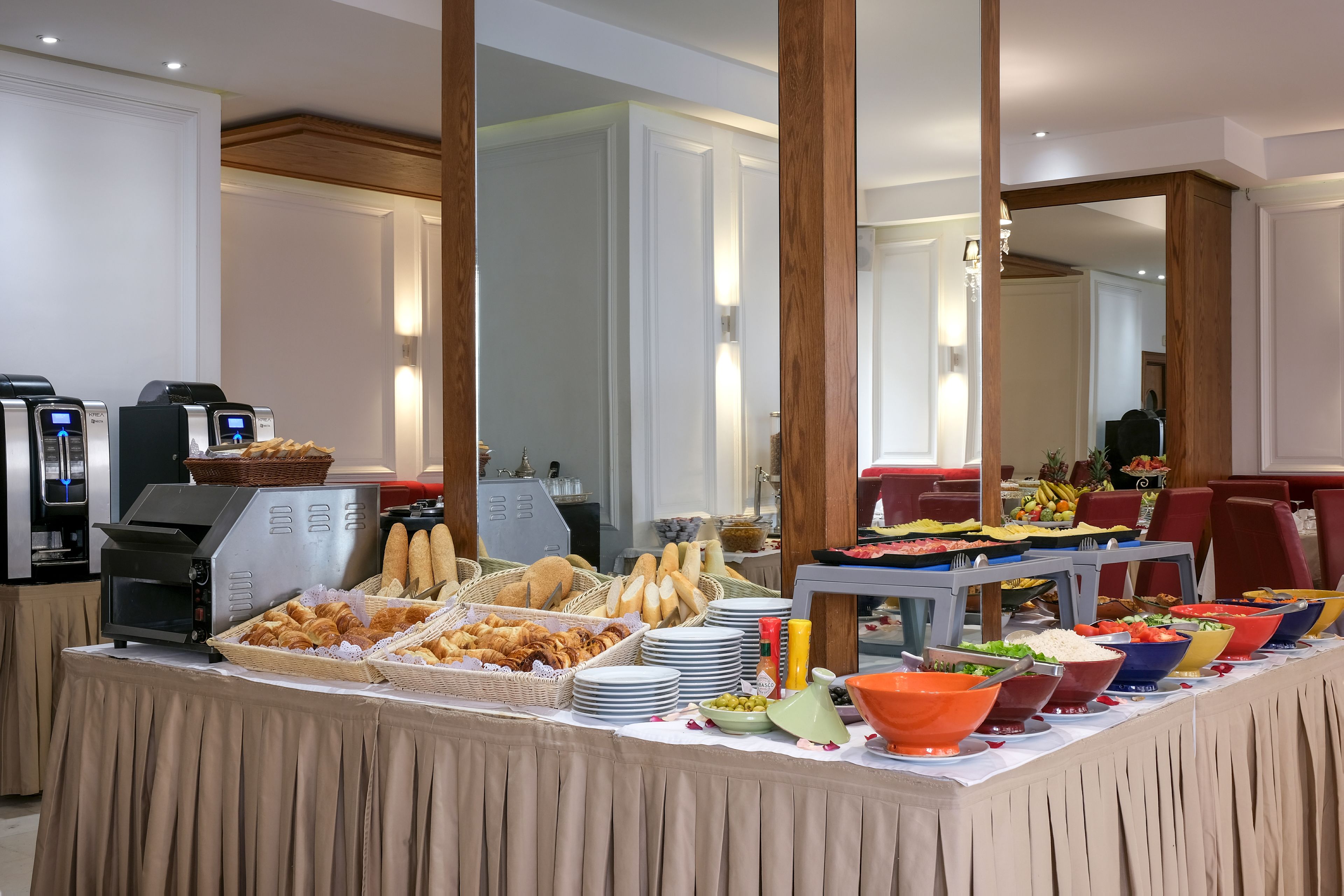 Una mesa de buffet con distintos alimentos y una máquina de café.
