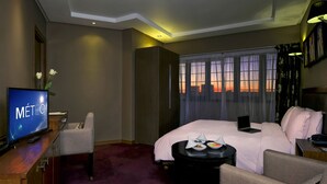 A hotel room with a bed, a desk, a chair, a TV, and a window with curtains. - Hotel Belere Rabat (Rabat)