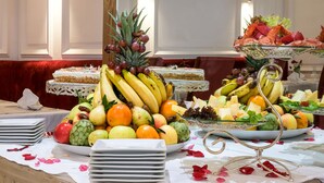 A buffet table with various fruits, a cake, and a lobster display. - Hotel Belere Rabat (Rabat)