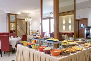 A buffet setup with various food items and a staircase in the background.