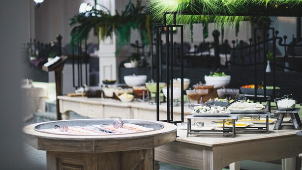 A buffet setup with various food items and utensils. - Alpin Resort Hotel (Brasov)