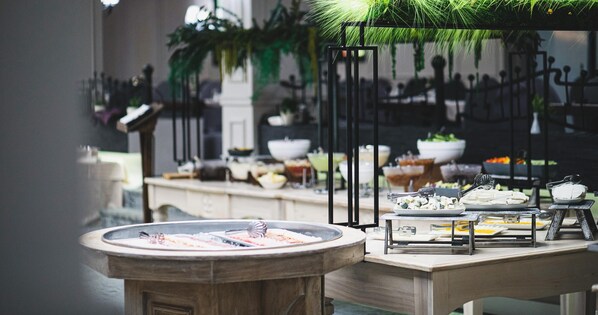 A buffet setup with various food items and utensils. - Alpin Resort Hotel (Brasov)