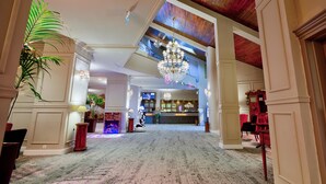 A spacious lobby with a high ceiling, a chandelier, and a reception desk. - Alpin Resort Hotel (Brasov)