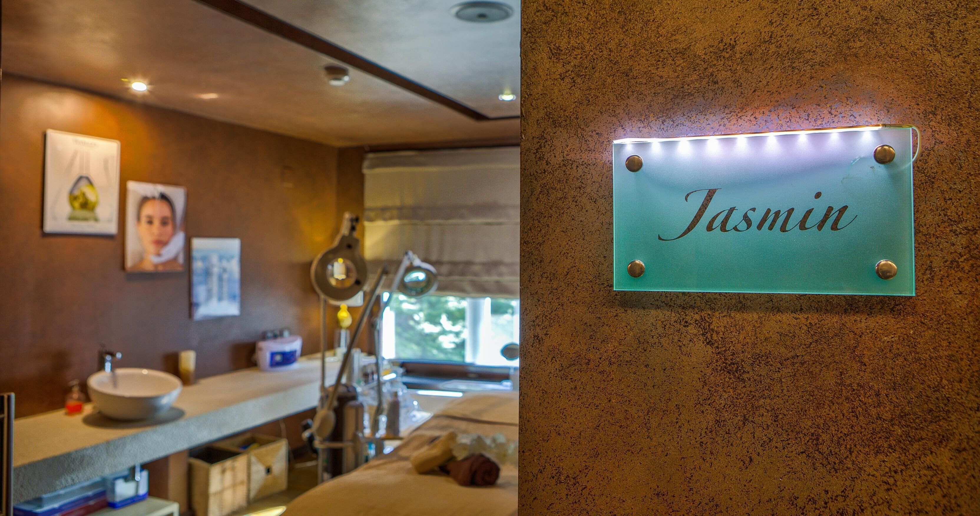 Un baño con lavamanos, espejo y un cartel que dice 'Jasmin'.