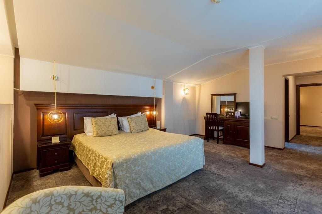 Una habitación de hotel con una cama grande, un escritorio y una silla.