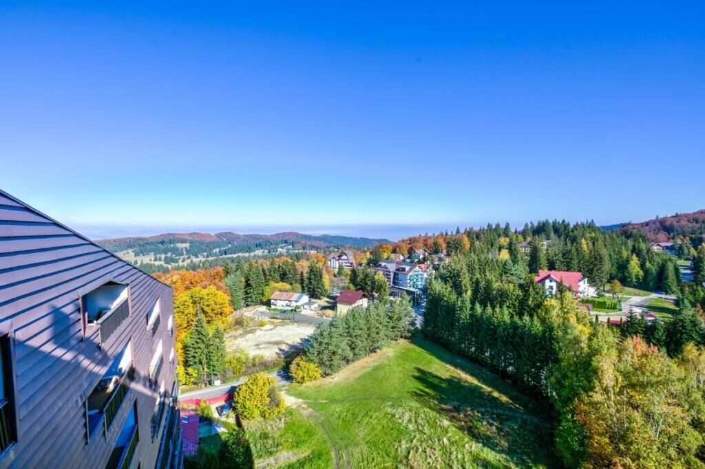 A residential area with houses, trees, and a clear sky.