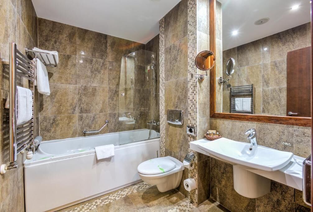 A modern bathroom with a bathtub, toilet, and sink.