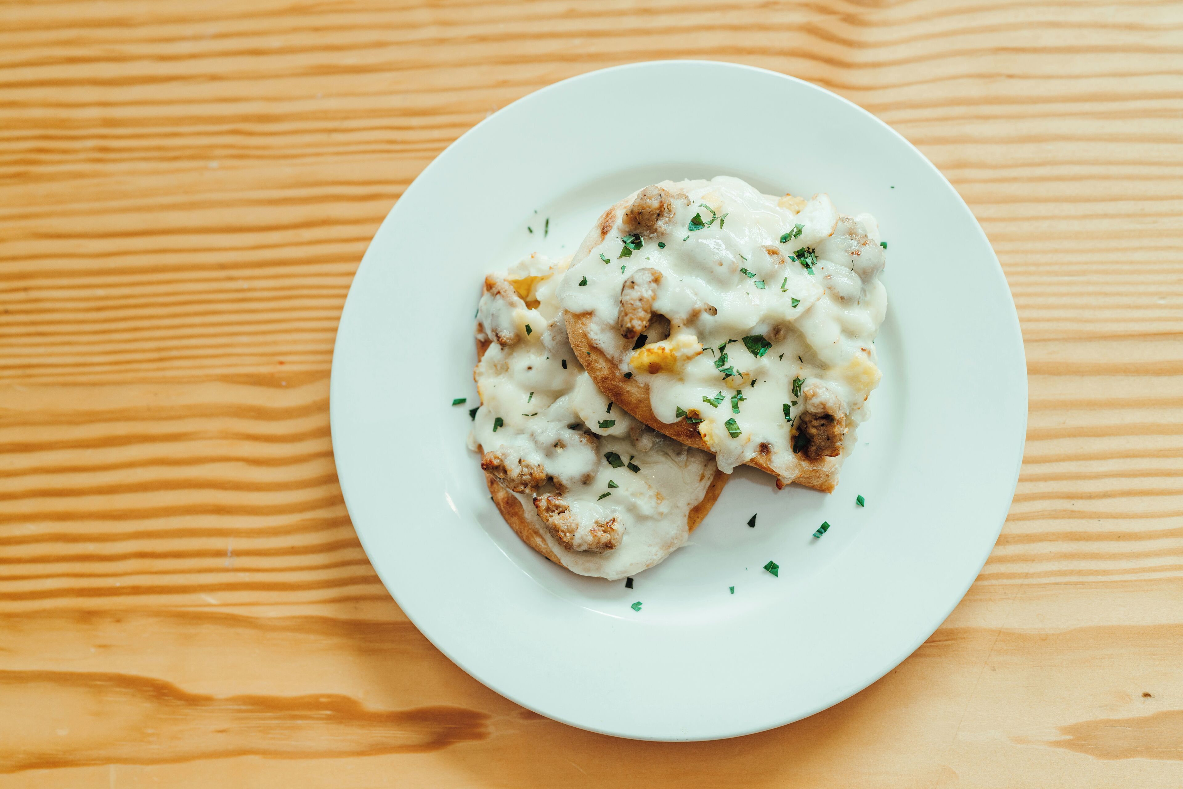 Un plato blanco con comida sobre una superficie de madera.