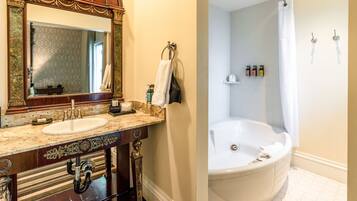 A bathroom with a double sink vanity, a large mirror, and a freestanding bathtub.