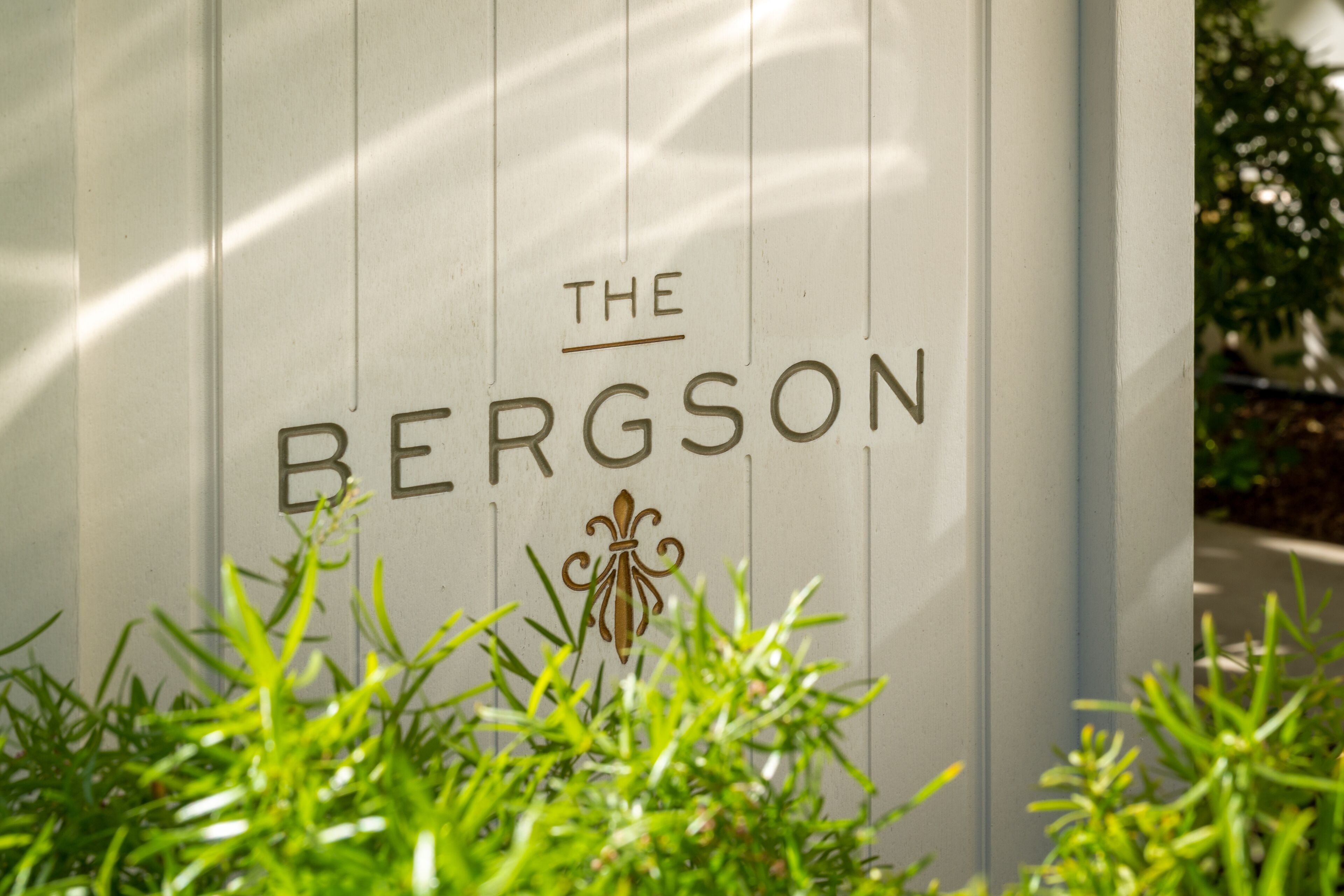 A sign with the text "THE BERGSON" and a decorative fleur-de-lis symbol.