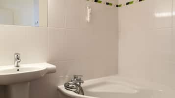 Un baño con lavabo, bañera y espejo.
