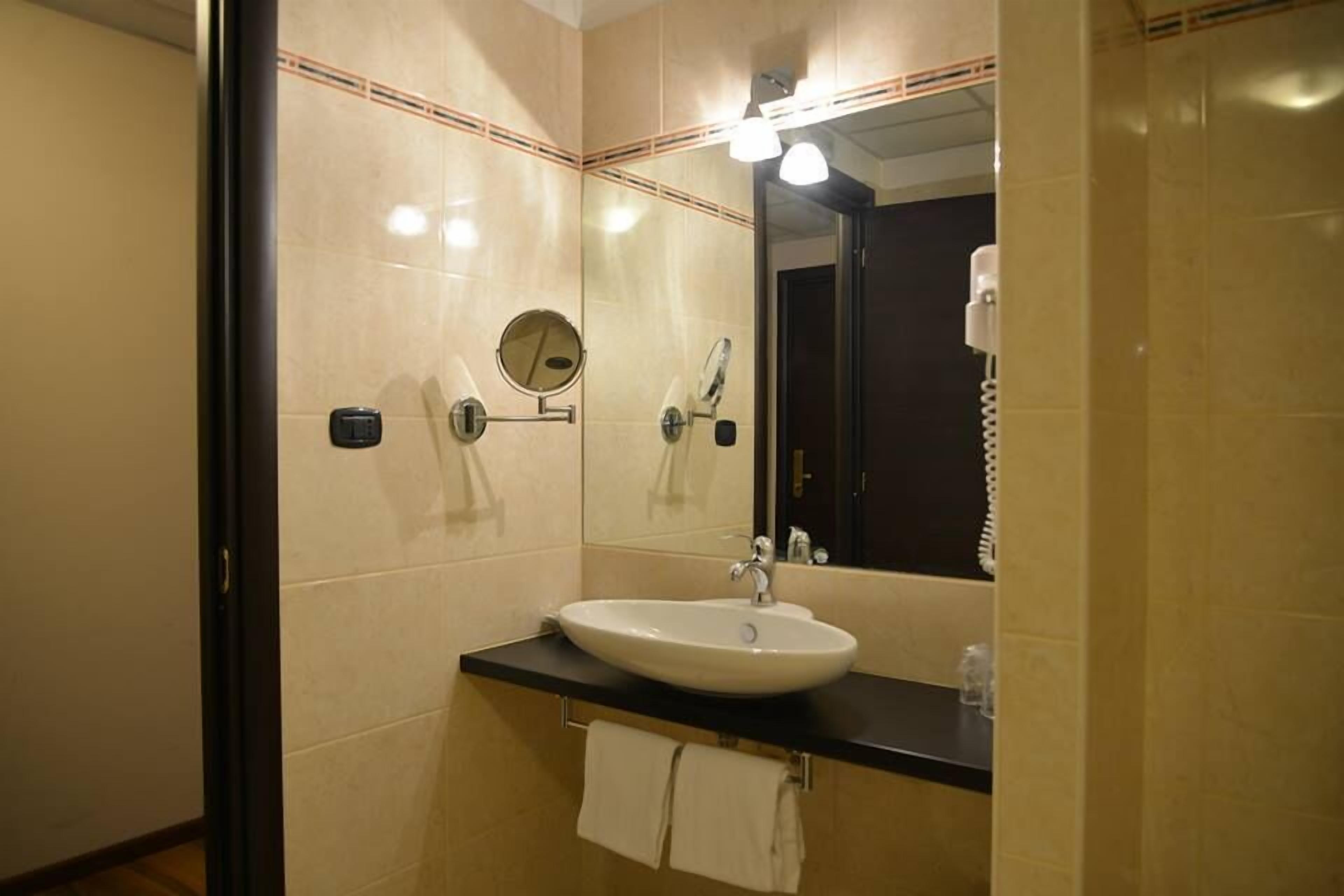 Ein Badezimmer mit Waschbecken, Spiegel und Handtuchhalter.