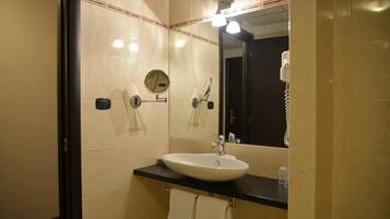 Ein Badezimmer mit Waschbecken, Spiegel und Handtuchhalter.