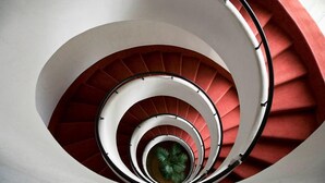 A spiral staircase with red steps and white railings. - Forum Palace Hotel (Cassino)