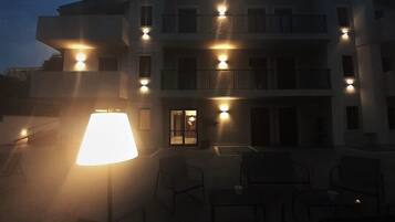 Un edificio de varios pisos con terraza y una lámpara.