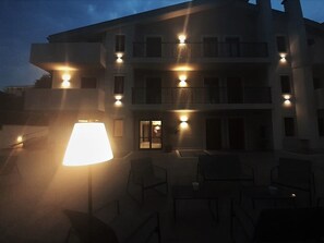 A multi-story building with outdoor seating and a lamp.
