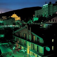 Un hotel con varios pisos, balcones y vistas de edificios circundantes.